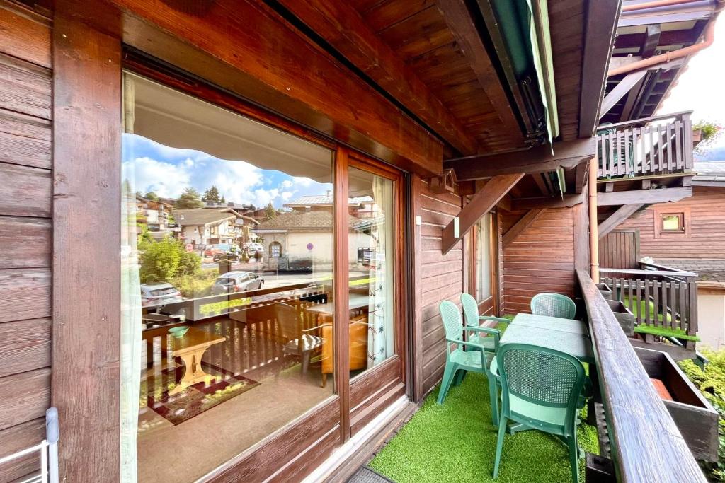 a balcony with a table and chairs and a large window at Cœur Combloran in Combloux