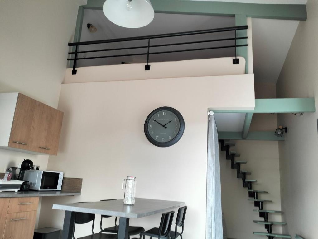 a room with a table and a clock on the wall at Petit studio cosy, calme absolu et indépendant in Gerzat