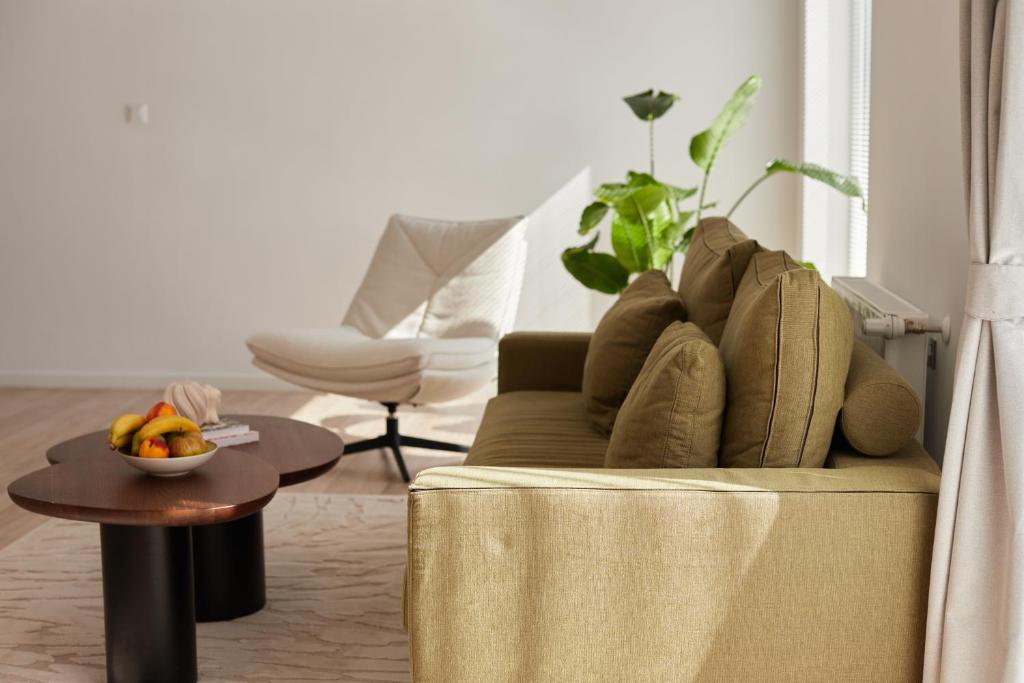 a living room with a couch and a bowl of fruit on a table at Lake side story in Frumuşani
