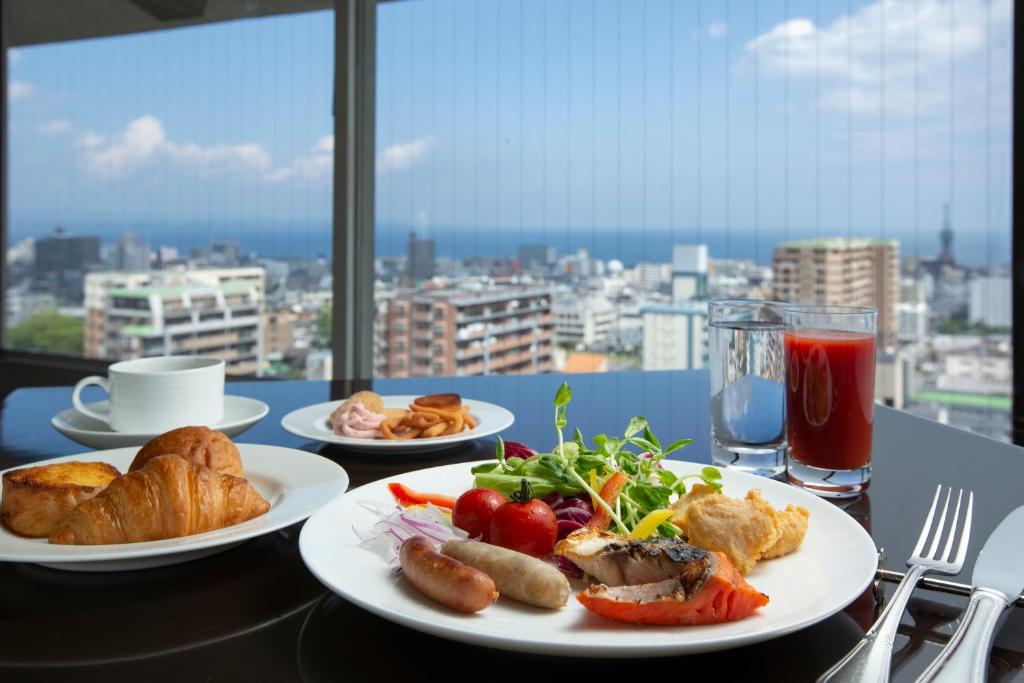 - une table avec des assiettes de nourriture et une vue sur la ville dans l'établissement Shiragiku, à Beppu