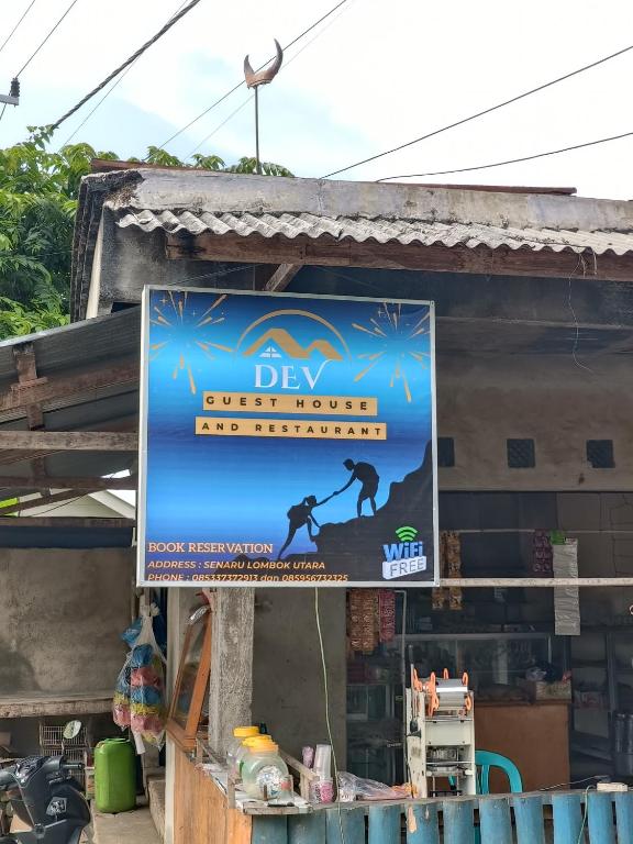 a sign in front of a building at Dev Guesthouse and Restaurant in Senaru