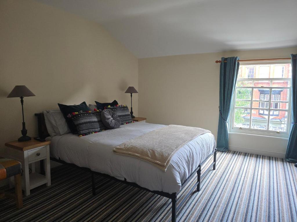 a bedroom with a bed with pillows and a window at Unicorn Hotel Llanidloes in Llanidloes