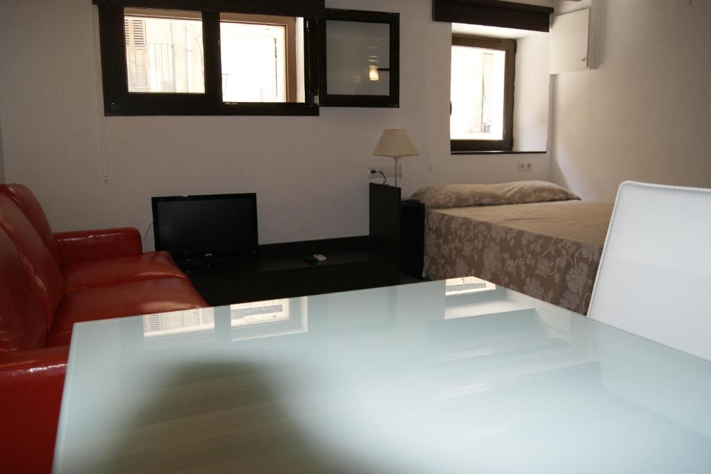 タラゴナにあるEstudio Cos Del Bouのベッド、ソファ、テーブルが備わる客室です。
