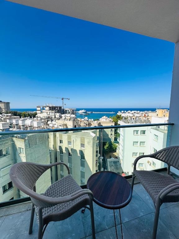 a balcony with chairs and a table and a view at North Residence Sea View Cozy Home in Kyrenia
