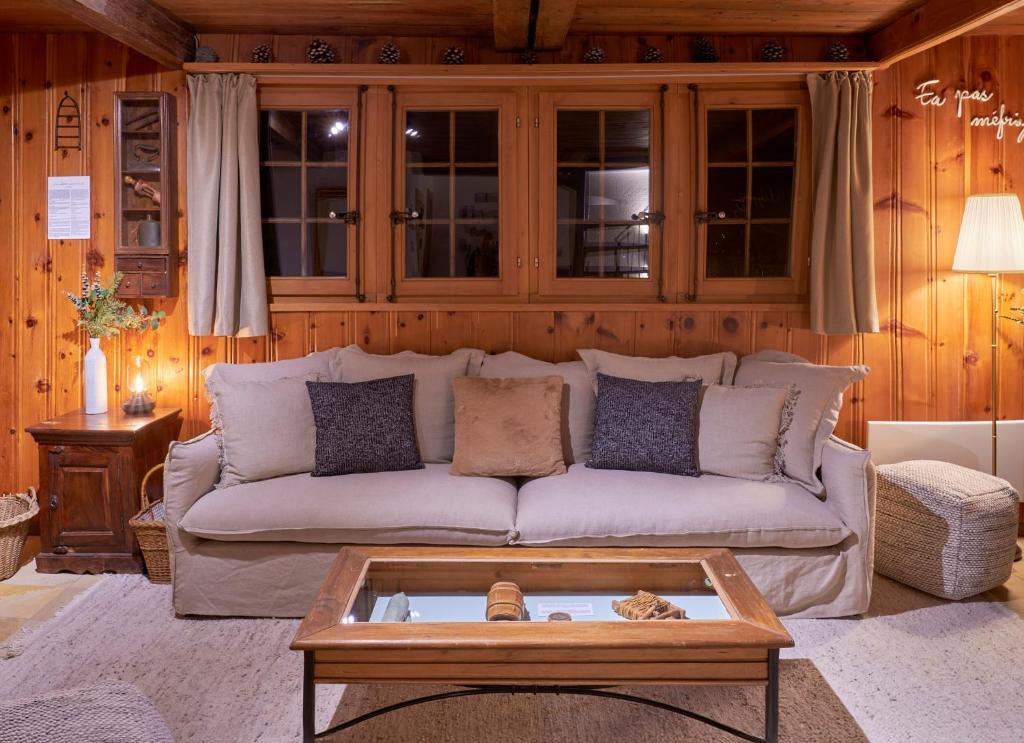 a living room with a couch and a coffee table at Chalet à thème, 2 chambres, vue sur les montagnes in Chalais