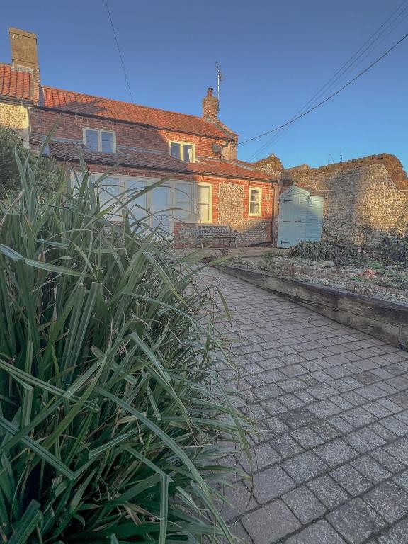 a house with a cobblestone street in front of it at Rural Cottage under 3 miles to Mundesley and Norfolk Coast in Knapton