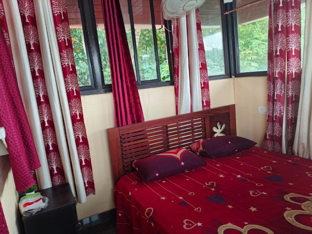 1 dormitorio con cama roja y cortinas rojas en Lake View Homestay Kundara, 