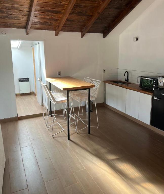 a kitchen with a table and chairs in a room at Nido 12 in San Carlos de Bariloche