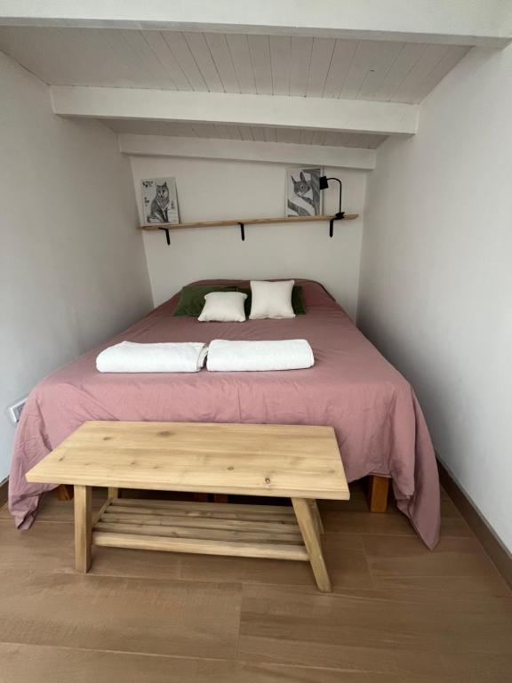 een bed in een kleine kamer met een houten tafel bij Nido 12 in Bariloche