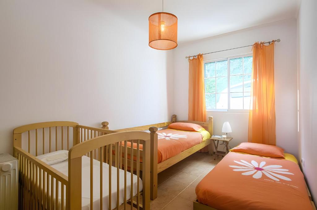 een slaapkamer met twee stapelbedden en een raam bij Beach House - Mountain And Ocean in Ribeira Seca do Porto