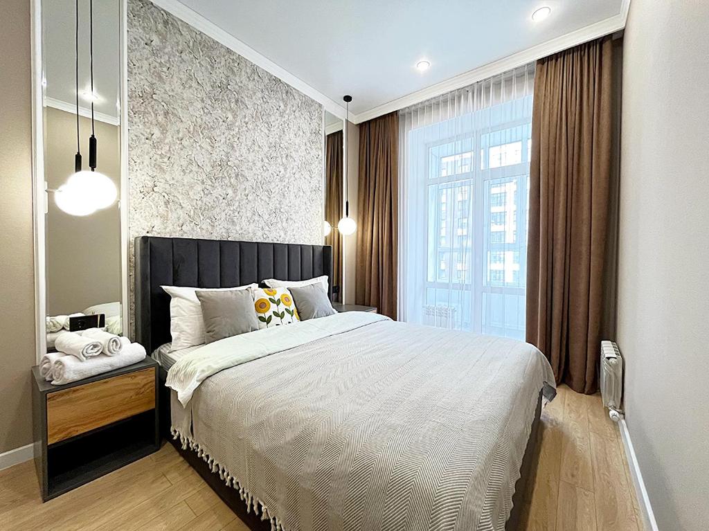 a bedroom with a large bed and a large window at Новая Евродвушка на Левом берегу Астаны, Экспо, МегаСилквэй in Astana