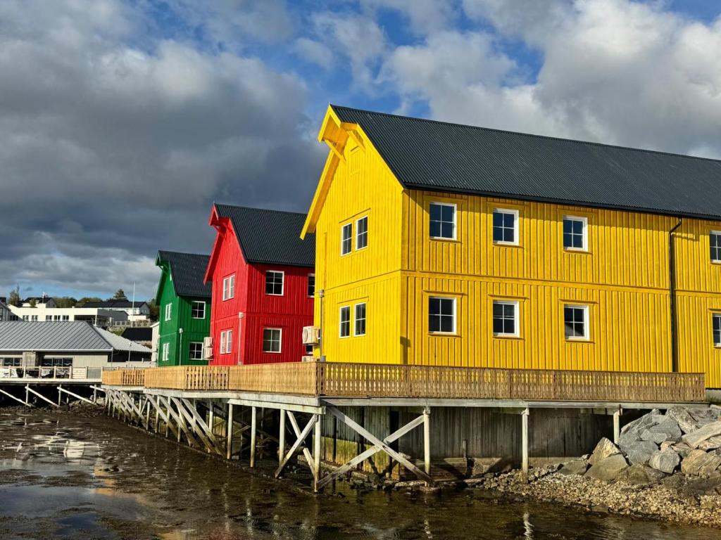 a yellow building on a pier next to the water at Martini Fishing Camp in Lauvsnes
