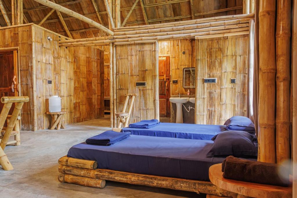 サクルシュプールにあるKaatiKaaduの木製の壁の部屋にベッドが2つある