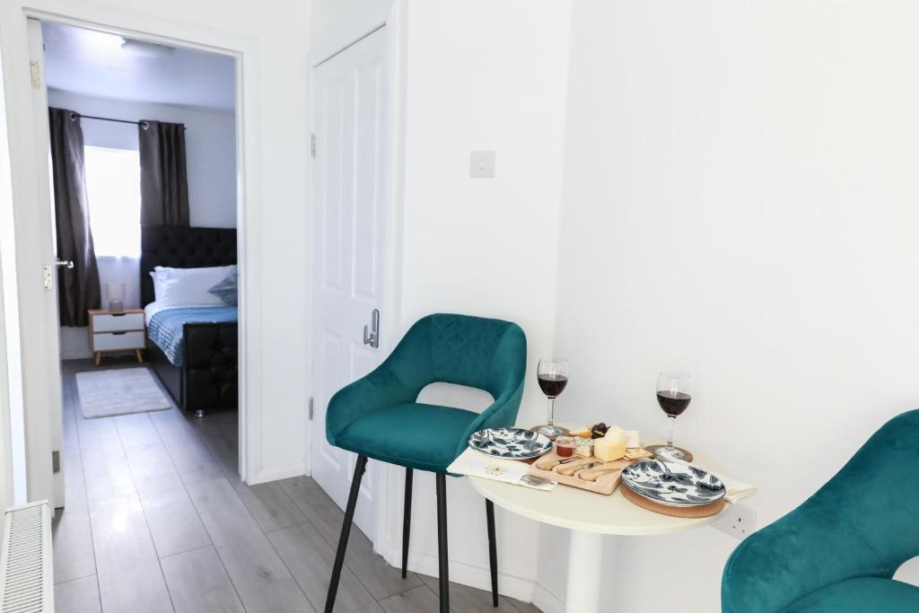 a room with a table and two green chairs at 4 Guests - 2 Bedrooms - City Escape Retreat in Stoke on Trent