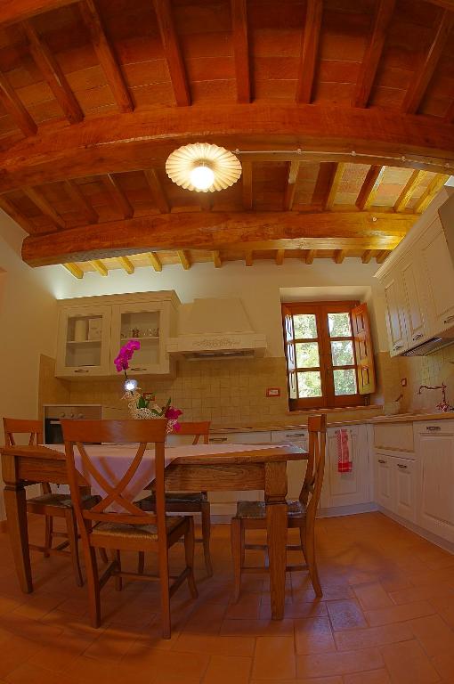 kuchnia z drewnianym stołem i jadalnią w obiekcie Borgo Buciardella w mieście Baschi