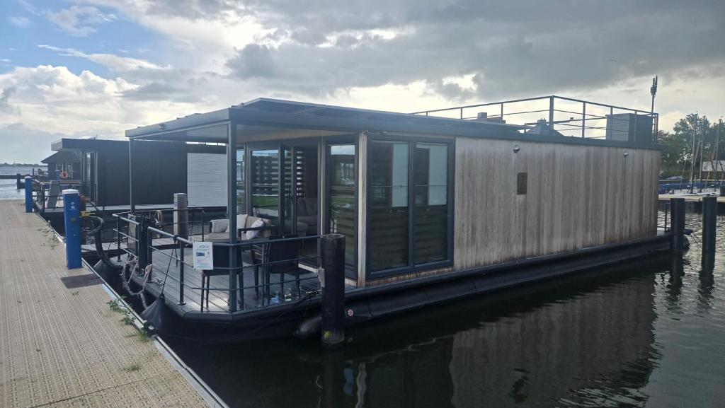 OffingawierにあるCastalia Houseboat met uitzicht over het Sneekermeerの水上桟橋に停泊した舟