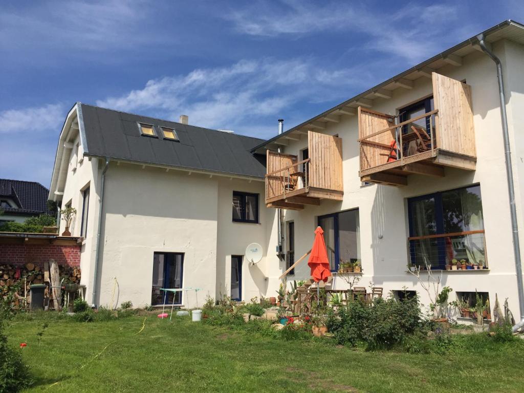 une maison blanche avec un toit noir et une cour dans l'établissement Hof Uhleck am Königsstuhl, à Lohme