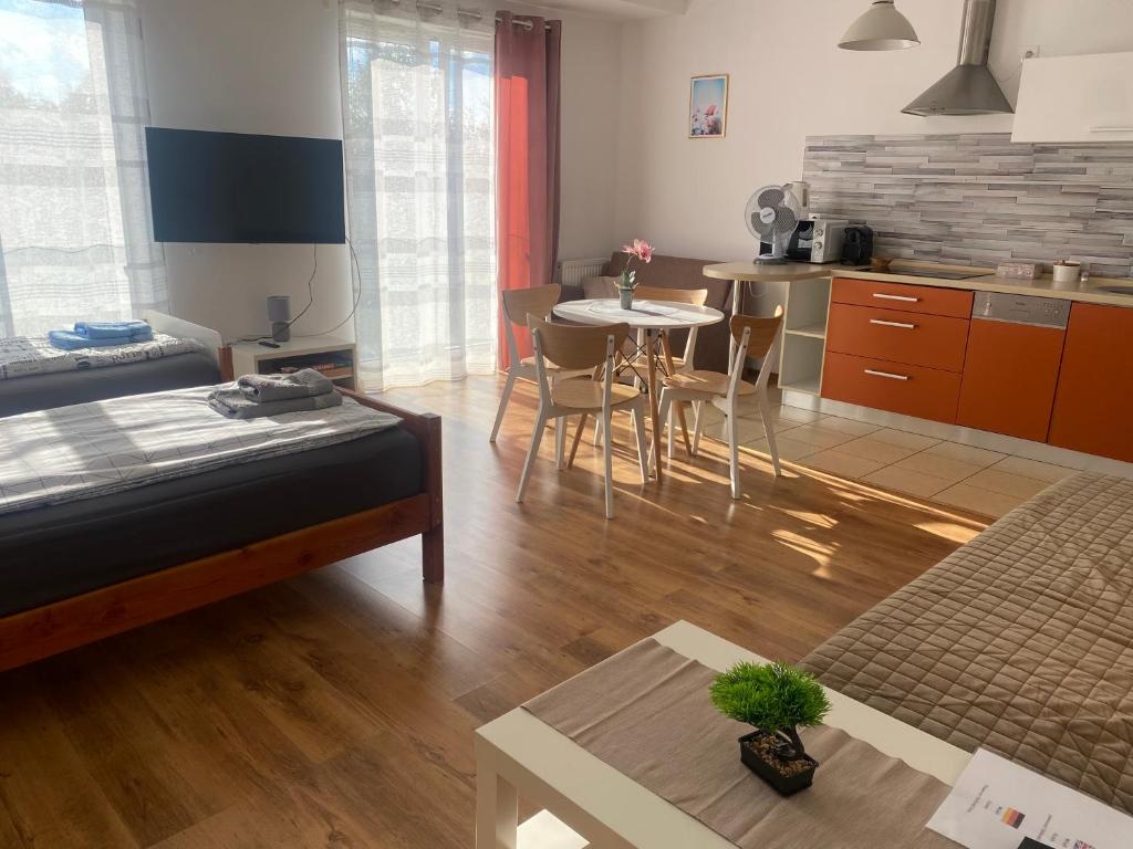 a room with a bed and a kitchen with a table at Apartament Bażantowo typu studio z parkingiem in Katowice