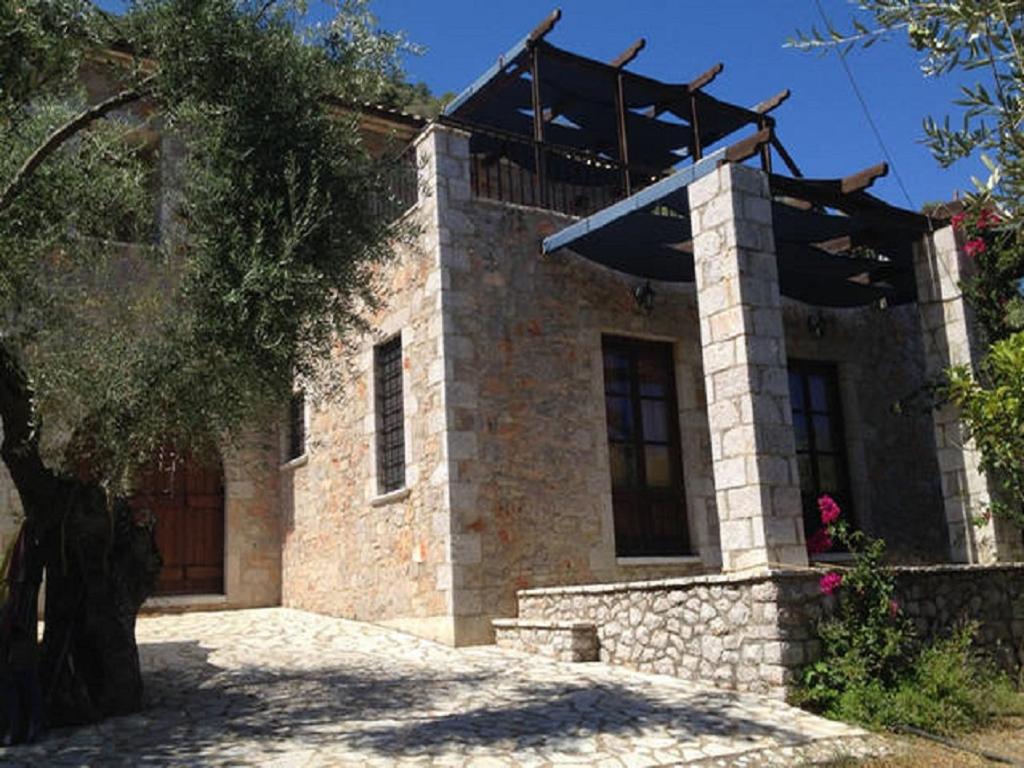 Leonidio Stone House في Pragmatevtís: منزل حجري فوقه سقف