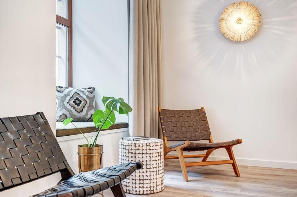 ein Wohnzimmer mit einem Stuhl und einer Pflanze in der Unterkunft Domillion Studio Modern Old Town Retreat So1b in Vilnius