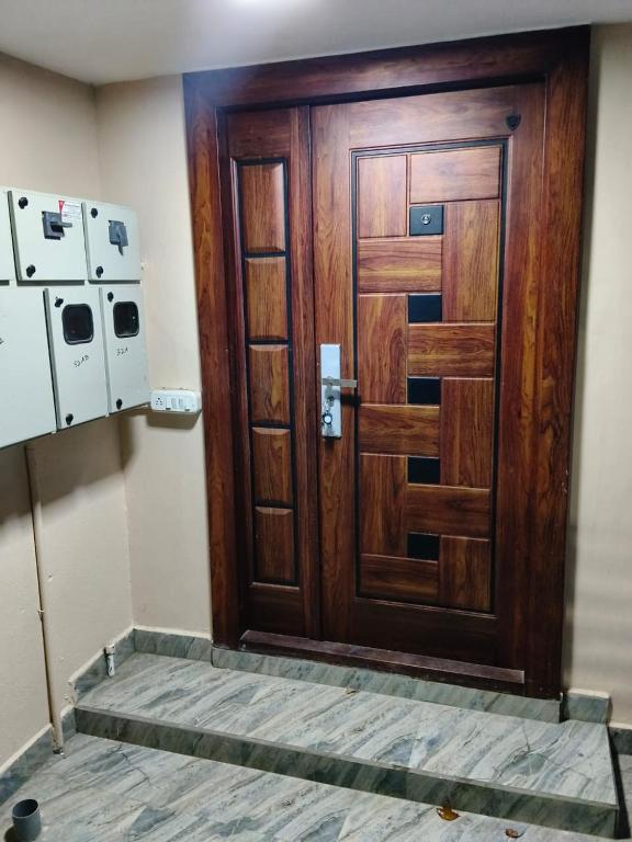 a brown wooden door in a room with aperature at Tenstay Homes & Independent Villa in Virāmpattinam