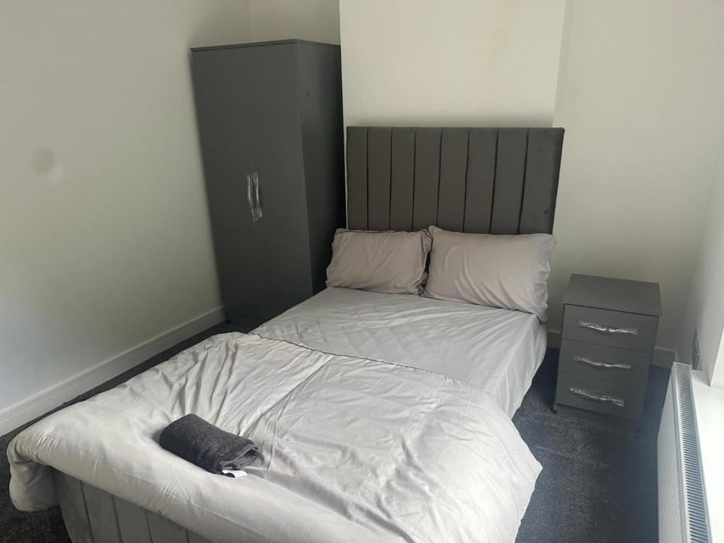 Un dormitorio con una cama con un gato acostado en ella. en Luton Room only, en Luton