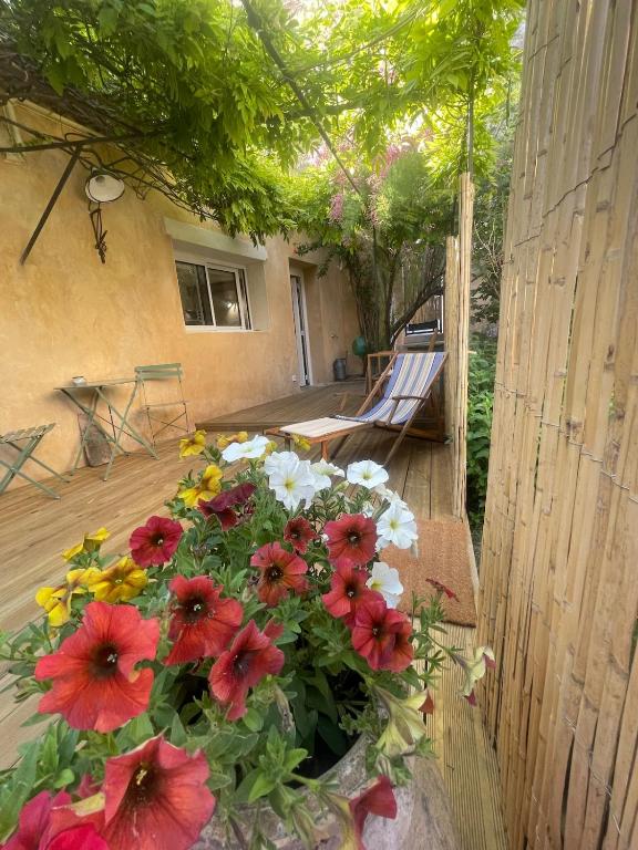 a bouquet of flowers in a vase on a porch at Studio Terrasse Le petit cabanon in Serres