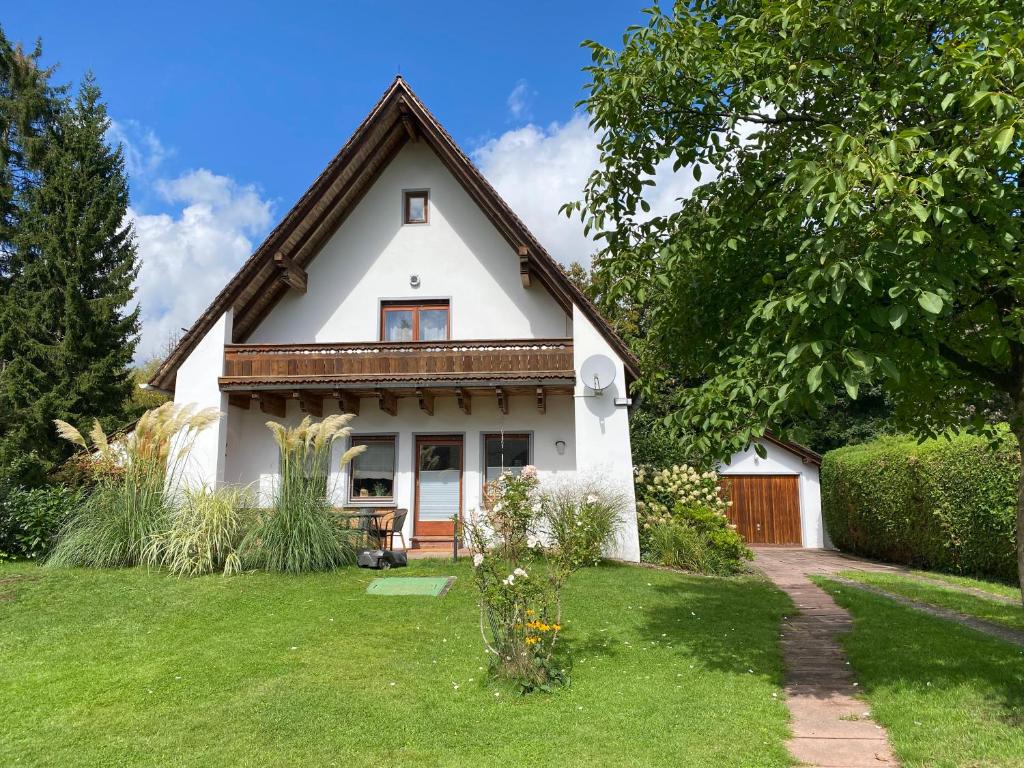 a small white house with a grass yard at Messe- & Ferienhaus Gertraud am Ludwigskanal, 24 h Self Check-In, Gratis parken in Wendelstein