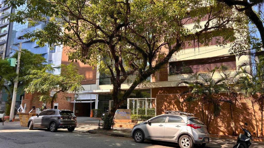 dos autos estacionados en una calle frente a un edificio en Book Santos Mar, Sol e Conforto no Unique 710 e 810, en Santos