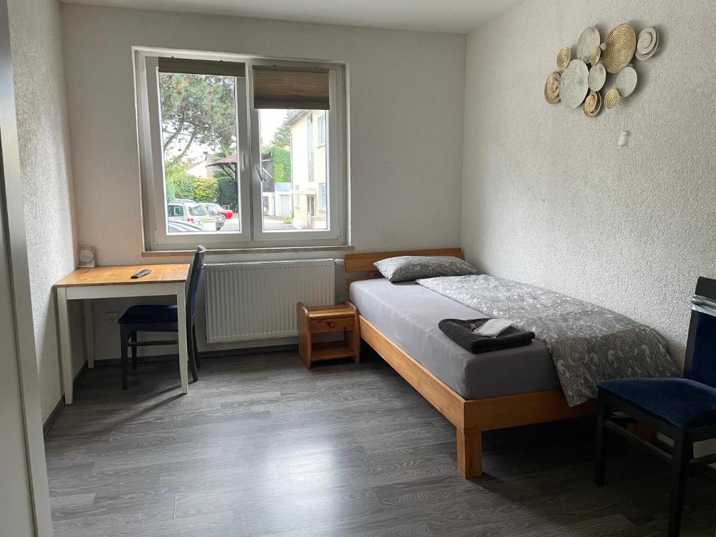 Un dormitorio con una cama y un escritorio y una ventana. en Pension & Monteurzimmer - Free Parking & 24h Check-in Bielefeld, en Bielefeld