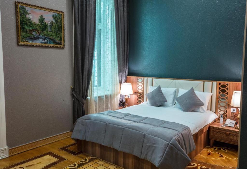 a bedroom with a large bed with a blue ceiling at Prestige Lodge Baku in Baku