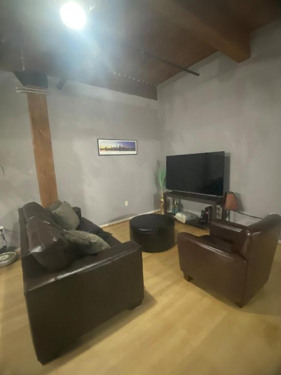 a living room with a couch and a flat screen tv at Washington Loft in Saint Louis