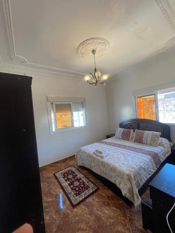 a bedroom with a bed and a chandelier at Oasis Privado Castillejos in Riffiene