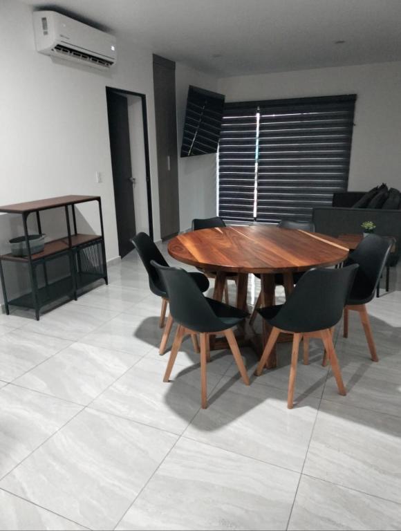 a wooden table and chairs in a living room at Marina Cerritos Mazatlan in La Florida
