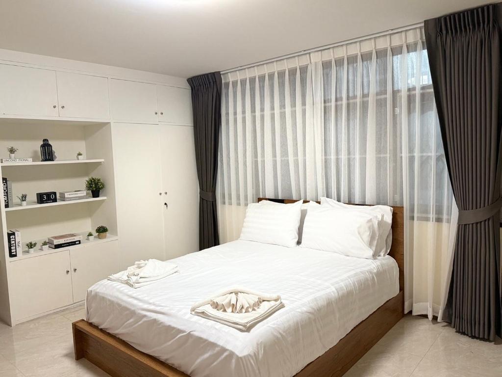 a bedroom with a bed with white sheets and a window at 10MIN 曼谷独栋Chatuchack,Kasetsart精品别墅 MYSTORY HOUSE in Ban O Pao