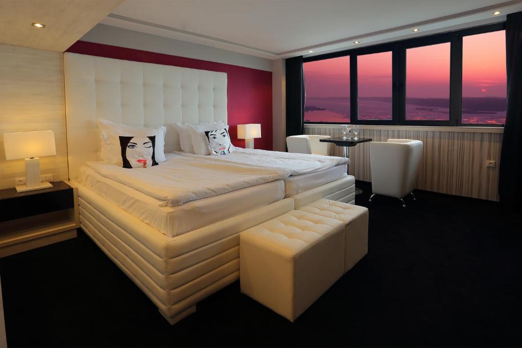 Grand Hotel Riga في روس: غرفة فندقية بسرير كبير ونوافذ