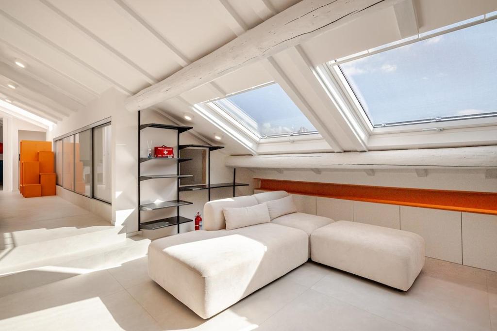 een woonkamer met een witte bank en een dakraam bij La Mansarda di Via Niella in Savona