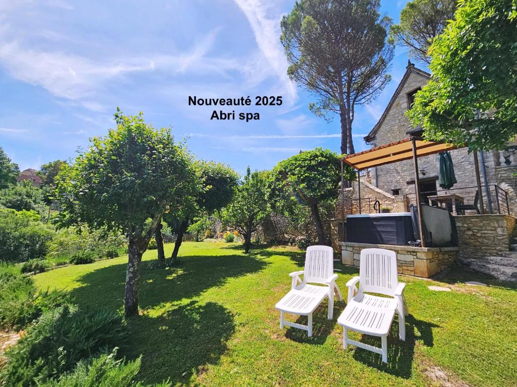 un paio di sedie bianche sedute in un cortile di La Pinay - Une petite maison cosy avec spa & cheminée a Lacave