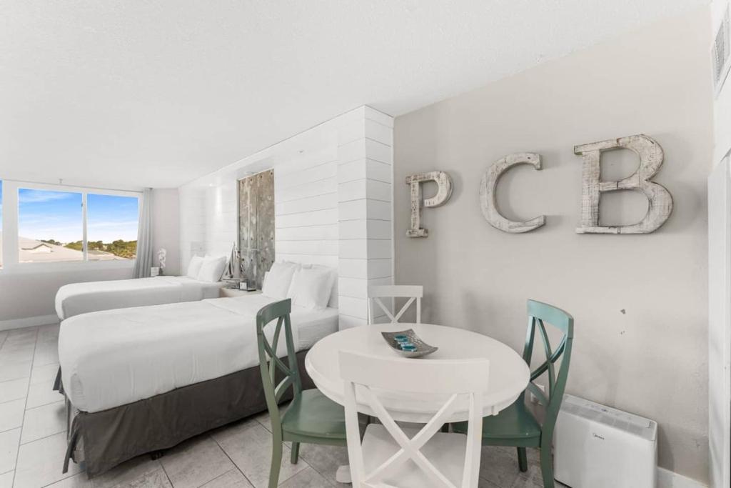une chambre d'hôtel avec un lit, une table et des chaises dans l'établissement Top Of The Gulf 506 Beachfront & Free Beach Chairs, à Panama City Beach
