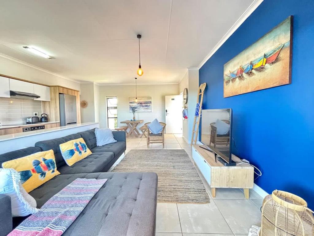 a living room with a couch and a blue wall at Beach Paradise in Ballito