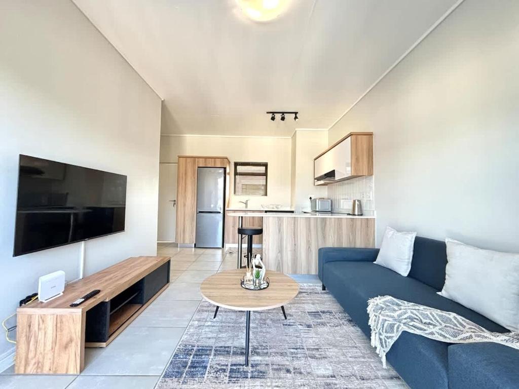 a living room with a blue couch and a table at Blissnest in Ballito