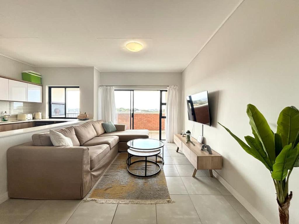 a living room with a couch and a table at Shoreline Sanctuary! in Ballito
