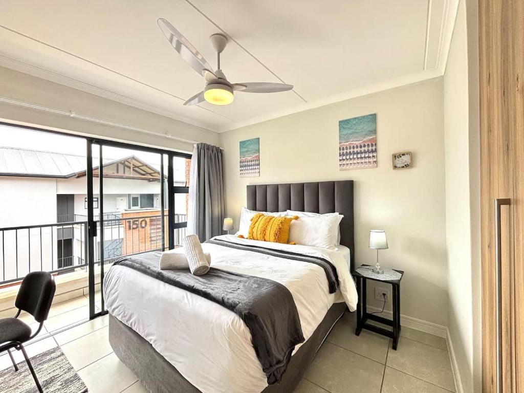 a bedroom with a bed and a balcony at The Pearl in Ballito