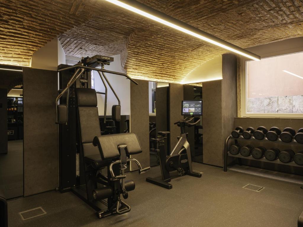 A well-equipped fitness room with resistance machines, weights, and a stationary bike.