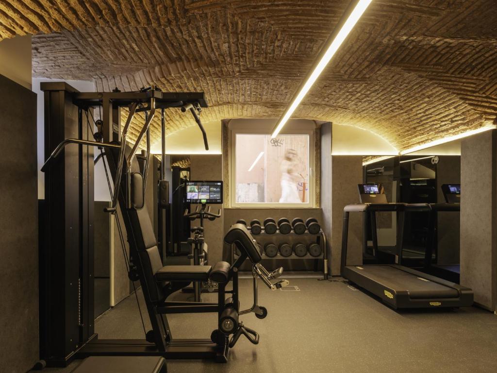 A compact hotel gym beneath a striking vaulted brick ceiling.