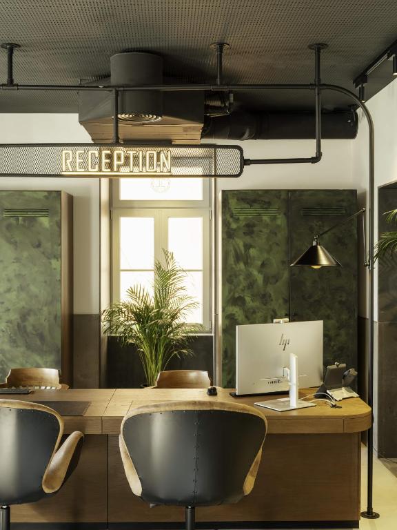 A reception desk doubles as a compact work area with a computer and two chairs.