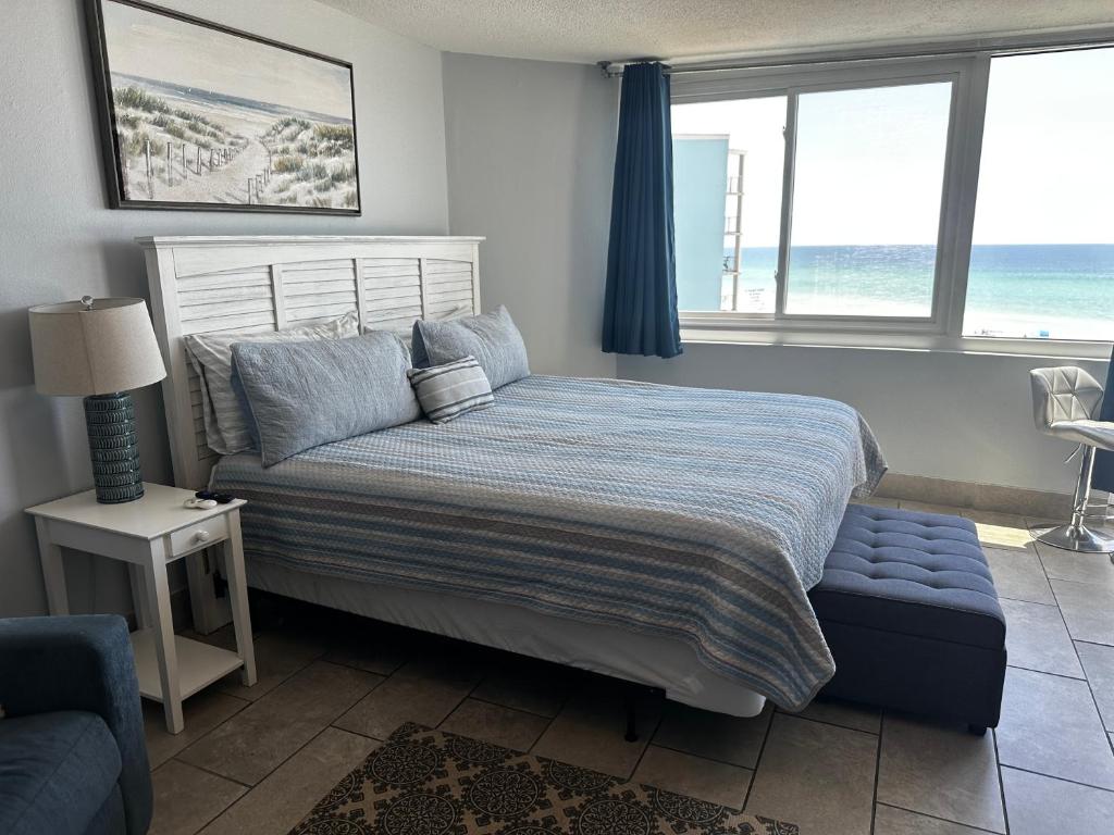 a bedroom with a bed and two windows at Beach Front Ocean View Condo - Top Of The Gulf 615 in Panama City Beach
