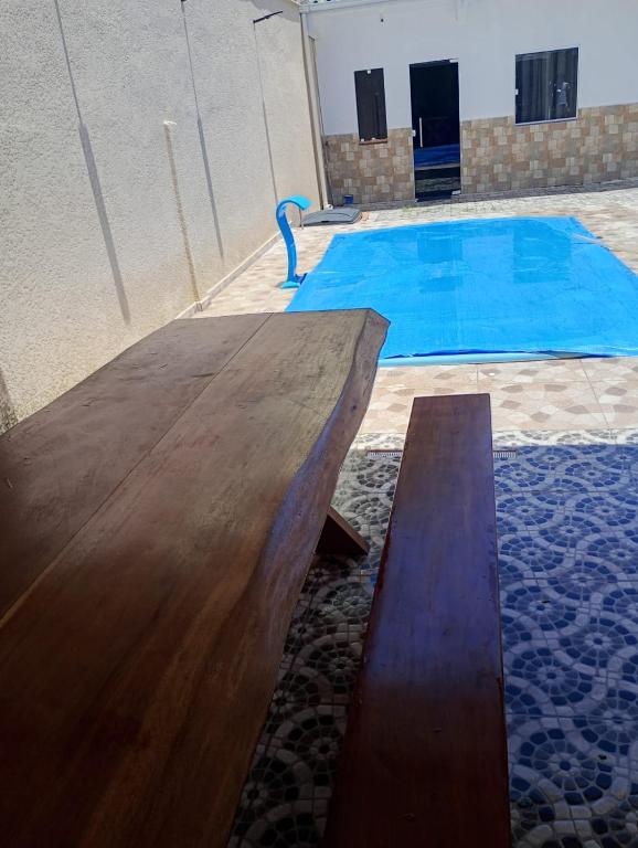 a wooden table in front of a swimming pool at Espaço Marques in Porto Seguro