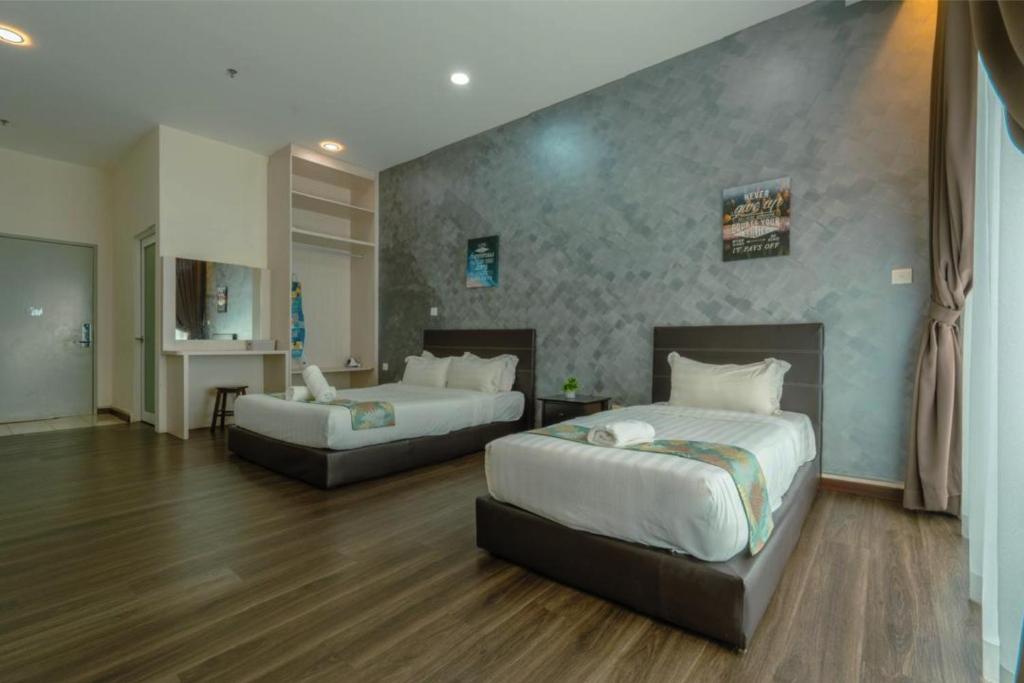 Una habitación de hotel con dos camas y un escritorio. en Aeropod Suites by J-Residences, en Kota Kinabalu