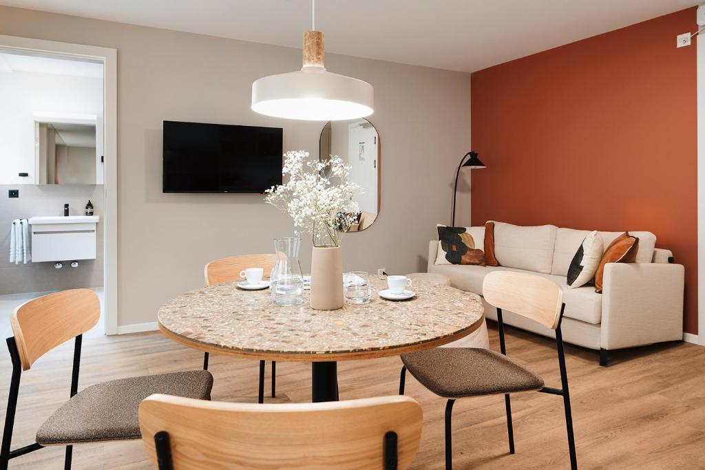 a living room with a table with chairs and a couch at Stay Sunday in Zurich